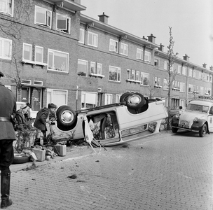 128756 Afbeelding van een over de kop geslagen auto in de Laan van Minsweerd te Utrecht, nadat de bestuurder van het ...